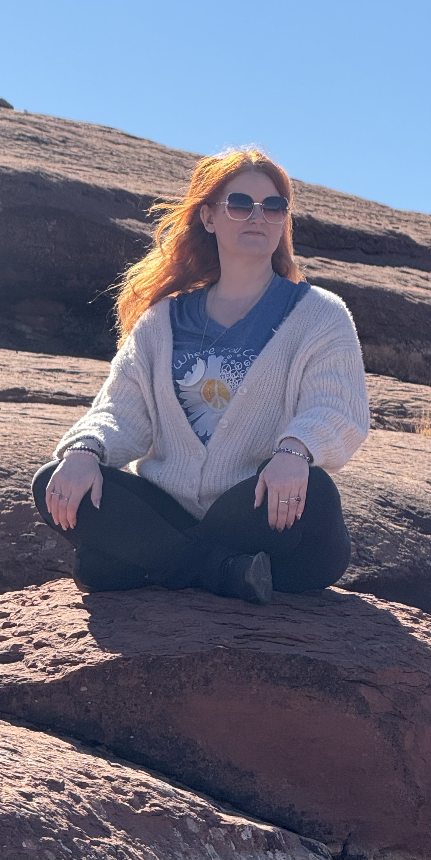 Diane meditating outdoors among red rocks